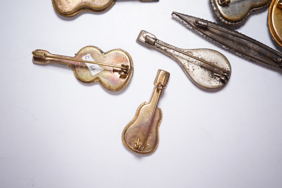A collection of twenty-eight brooches, including fourteen mixed guitar and banjo shaped brooches, six large oval brooches, seven smaller brooches and one small oval., Condition - good